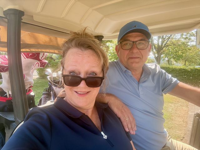 Marianne en Rogier, de makers van GolfScore, in een golfkar op de baan